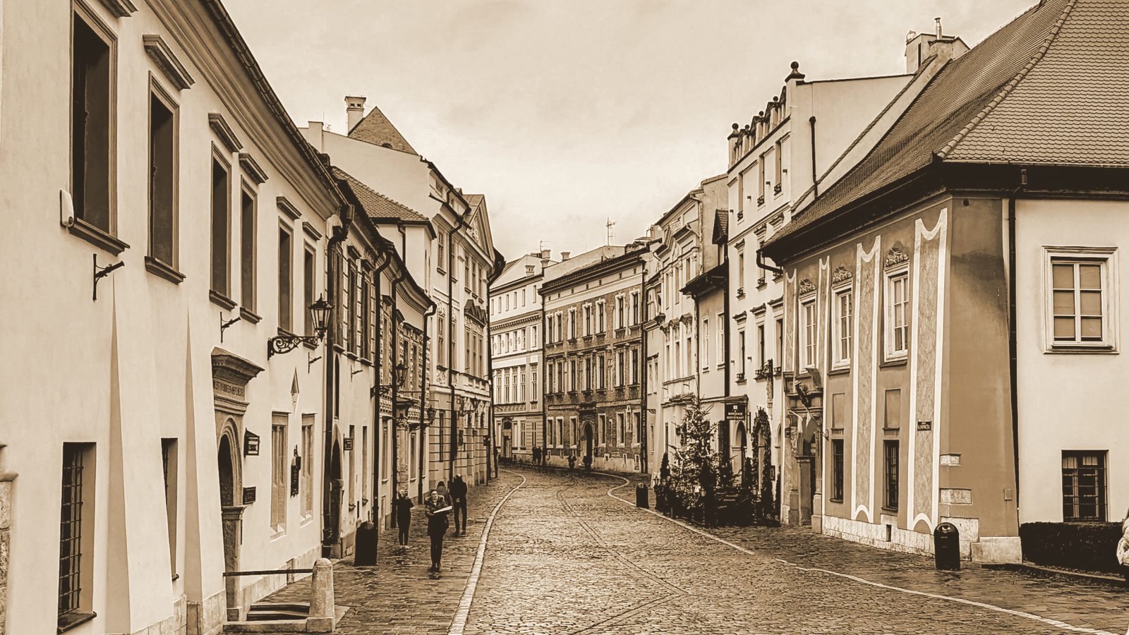 Brukowana uliczka krakowskiego Starego Miasta z kamienicami po obu stronach.